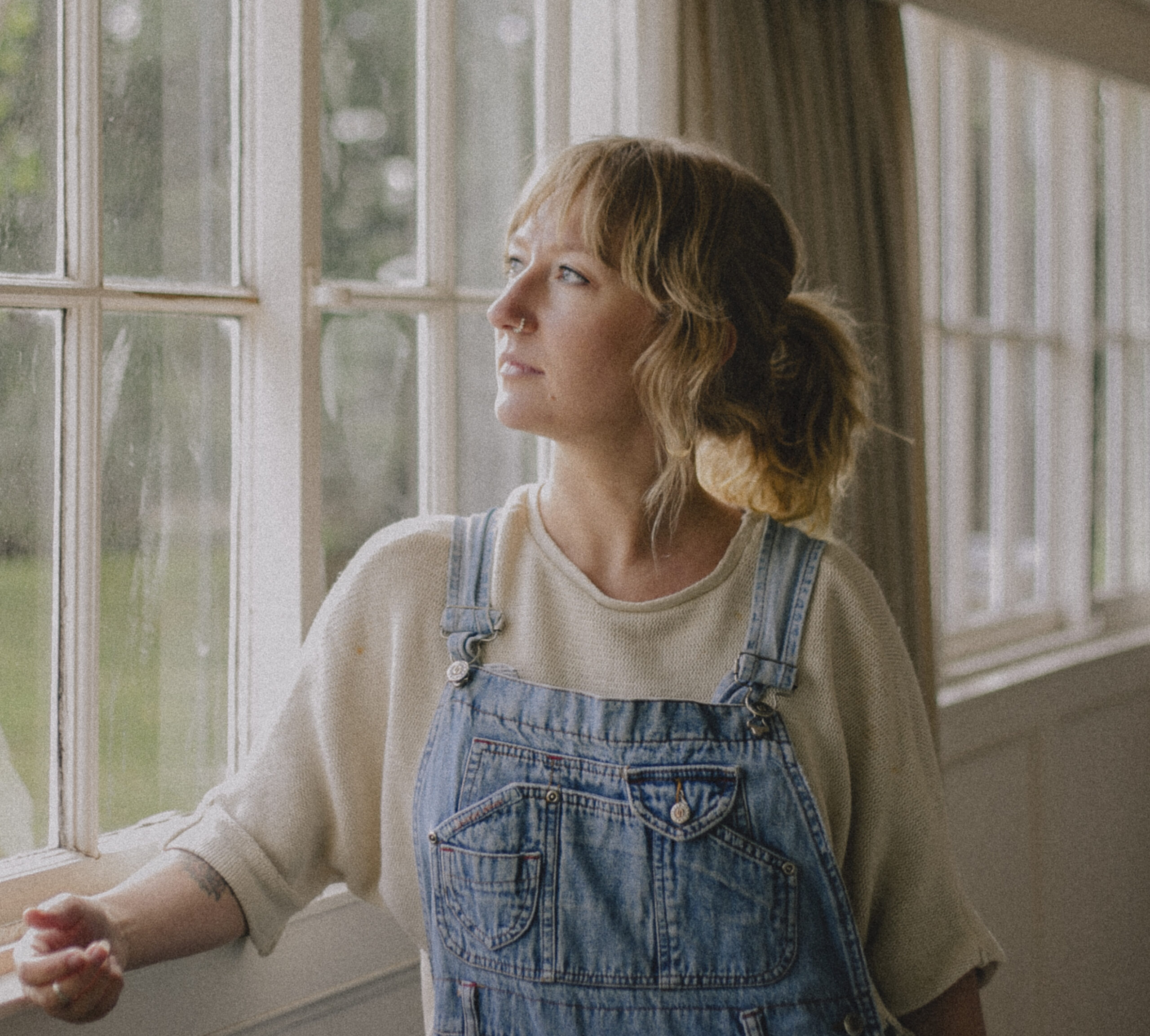 Alana Wilkinson appears in three-quarter profile, looking out of a window